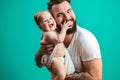 Playful father carrying his smiling infant child on neck over blue background Royalty Free Stock Photo