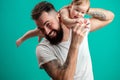 Playful father carrying his smiling infant child on neck over blue background Royalty Free Stock Photo