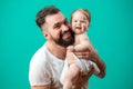 Playful father carrying his smiling infant child on neck over blue background Royalty Free Stock Photo