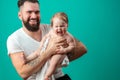 Playful father carrying his smiling infant child on neck over blue background Royalty Free Stock Photo