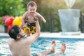 Playful father and son having fun in water.