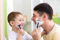 Playful father and son shaving together at home bathroom