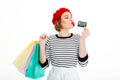 Playful ginger woman holding packages and playing with credit card