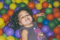 Playful girl lying in ball pit Royalty Free Stock Photo