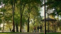 Playful girl running park path playing with parents. Cheerful childhood moments. Royalty Free Stock Photo