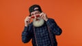 Playful happy elderly bearded man in sunglasses and cap blinking eye, looking at camera with smile