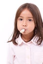 Playful, happy, smiling cute little girl eating marshmallow