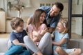 Playful happy young man with children tickling laughing wife mother. Royalty Free Stock Photo