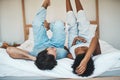 Playful interracial couple bonding while lying on a bed in a bedroom in the morning. Loving, resting and relaxing Royalty Free Stock Photo