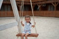 Playful kid swinging swing. Joyful little girl play having fun playground summertime