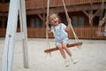 Playful kid swinging swing. Joyful little girl play having fun playground summertime Royalty Free Stock Photo