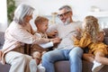 Playful kids and grandmother tickling grandpa while spending time together on weekend Royalty Free Stock Photo