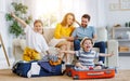 Playful kids in suitcases with parents on sofa behind Royalty Free Stock Photo