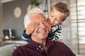 Playful little boy covering grandpa`s eyes Royalty Free Stock Photo