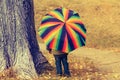 Playful little child hiding behind colorful umbrella Royalty Free Stock Photo