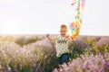 Playful little cute child baby boy walk on purple lavender flower meadow field, run, have fun, play with colorful kite Royalty Free Stock Photo