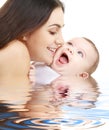 Playful mama with happy baby in water