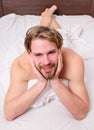 Playful mood concept. Guy macho lay white bedclothes. Pleasant relax concept. Man unshaven handsome happy smiling Royalty Free Stock Photo