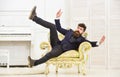 Playful mood concept. Man with beard and mustache wearing fashionable classic suit, sits, jumps on old fashioned Royalty Free Stock Photo