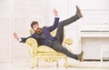 Playful mood concept. Man with beard and mustache wearing fashionable classic suit, sits, jumps on old fashioned Royalty Free Stock Photo