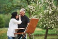 Playful mood. Mature couple have leisure days and working on the paint together in the park Royalty Free Stock Photo