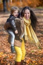 Playful mother giving piggyback ride to her son. Royalty Free Stock Photo