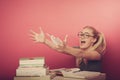 Playful, naughty schoolgirl with big eyeglasses playing with pap Royalty Free Stock Photo