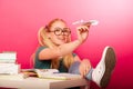 Playful, naughty schoolgirl with big eyeglasses throwing paper a Royalty Free Stock Photo