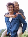 Playful piggybacking. A young woman recieving a piggyback ride from her boyfriend. Royalty Free Stock Photo