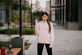 Playful portrait of pretty young woman, having fun at the street.