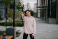 Playful portrait of pretty young woman, having fun at the street.