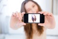 Playful positive woman winking and taking selfie with smartphone