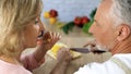 Playful senior couple cooking vegetable dinner at home, family togetherness Royalty Free Stock Photo