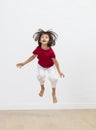 Playful child with hair all over enjoying jumping with joy