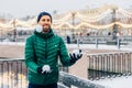 Playful smiling male juggles with snowballs throws them in air,