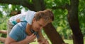 Playful son riding on back blond man closeup. Smiling father lift up cute boy.