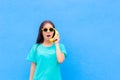 Funny Girl with Sunglasses and Banana Phone on Blue Background Royalty Free Stock Photo