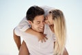 Playful Summer Romance. A handsome young man giving his girlfriend a piggyback ride outside. Royalty Free Stock Photo