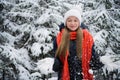 A playful teenage girl with a beautiful smile throws snow flakes and rejoices at the onset of the long-awaited winter.