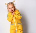 Playful toddler girl dressed in a warm yellow sports jumpsuit. Royalty Free Stock Photo