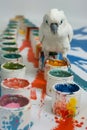 Playful White Cockatoo Perched on Colorful Paint Cans Creating Artistic Masterpiece on Canvas in Art Studio