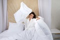 Beautiful young woman sits on the bed and throws a pillow in hotel having fun on weekend at home Royalty Free Stock Photo