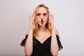 Playful young blonde with red lips making fish face, young woman having fun, being crazy. Wearing pink stylish glasses Royalty Free Stock Photo