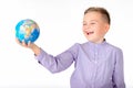 Playful young caucasian school boy holding a globe on white studio background.Boy shows globe laughing Royalty Free Stock Photo