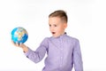 Playful young caucasian school boy holding a globe on white studio background.Boy is surprised Royalty Free Stock Photo