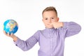 Playful young caucasian school boy holding a globe on white studio background.Boy shows at globe laughing Royalty Free Stock Photo