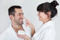 Playful young couple applying cream