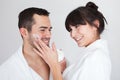 Playful young couple applying cream