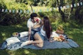 Playful young couple having picnic in city park He wears red nose Royalty Free Stock Photo