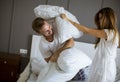 Playful young couple having pillow fight on bed Royalty Free Stock Photo